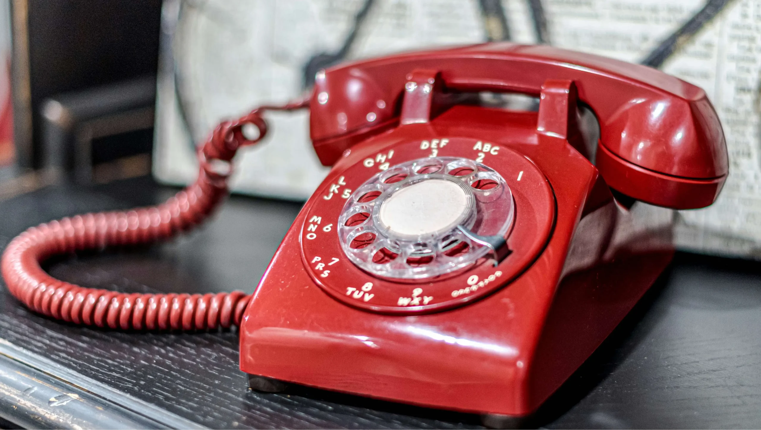 Rød retro drejeskivetelefon på mørkt underlag