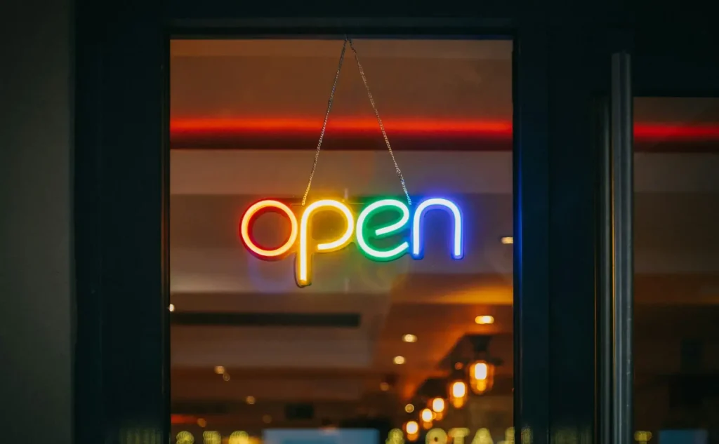 Et lysende open-skilt i vinduet, der markerer overgangen fra idé til virkelighed, når du stifter din egen virksomhed.